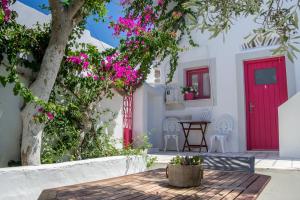 a red door on a white house with pink flowers at Margo Antiparos in Antiparos
