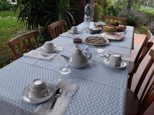 a table with teapots and plates of food on it at La collina degli olivi in Carmignano