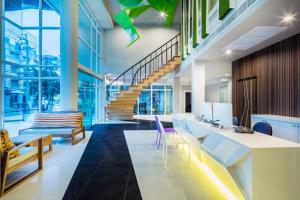 an office lobby with a staircase and chairs at Atelier Suites in Bangkok