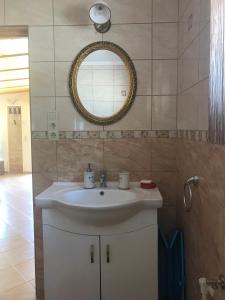 a bathroom with a white sink and a mirror at Kenese Panoráma Apartman in Balatonkenese