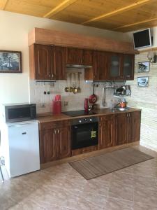 バラトンケネシェにあるKenese Panoráma Apartmanのキッチン(木製キャビネット、白い冷蔵庫付)