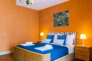 sypialnia z niebiesko-białym łóżkiem z 2 lampami w obiekcie Les Suites - Apartments w mieście Riposto