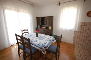 a dining room with a table and chairs with a table at Apartment Alex in Njivice