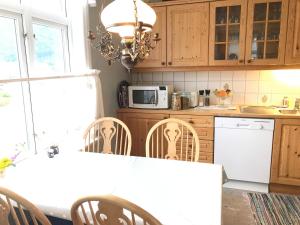 a kitchen with a table with chairs and a microwave at Villa Holmen in Balestrand +18 photos