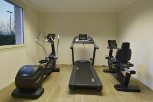 a gym with treadmills and exercise bikes in a room at Tulip Inn Turin West Rivoli in Rivoli