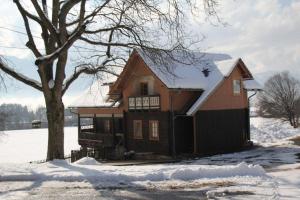 dom w śniegu z drzewem w obiekcie Landhaus Löscher w mieście Seeboden