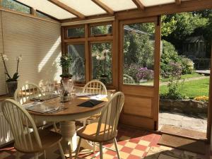 a wooden table and chairs on a patio at Bells Cottage in Alderton +33 photos