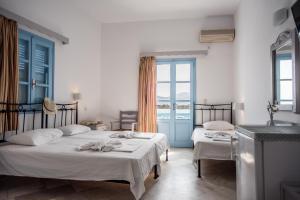 a bedroom with two beds with towels on them at Hotel Mantalena in Antiparos Town