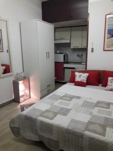 a bedroom with a large bed and a kitchen at Apartment Rosse in Split