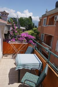 einen Balkon mit einem Tisch, Stühlen und Blumen in der Unterkunft Apartmani Abeona in Budva