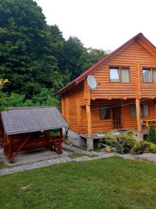a wooden house with a picnic table in front of it at Guest House Smerichka in Shaian