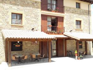 an outdoor patio with tables and chairs in front of a building at Hospedería Prepirineo in Undués-Pintano