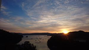 a sunset over a river with birds in the water at Resorpia Kumihama in Kyotango
