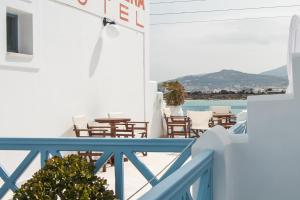 a balcony with tables and chairs and a view of the ocean at Hotel Mantalena in Antiparos Town