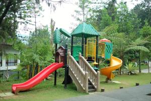 um parque infantil com um escorrega e um conjunto de jogos em The Grand Hill Resort-Hotel em Puncak