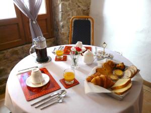 - une table blanche avec un plateau de pain et du jus d'orange dans l'établissement The Old Well Bed and Breakfast, à Pézenas