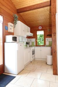 a kitchen with white appliances and a wooden ceiling at Chalet de Grettery in Saulxures-sur-Moselotte