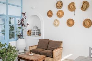 a living room with a couch and hats on the wall at Hotel Mantalena in Antiparos Town