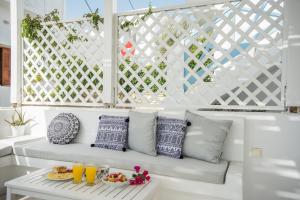 a white bench with pillows and a tray of fruit at Hotel Mantalena in Antiparos Town
