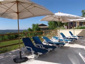 een groep stoelen en parasols op een patio bij Apartamentos Casa Sanz in Asque