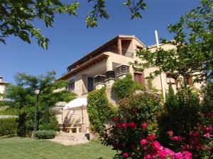 una casa grande con flores delante en Apartamentos Casa Sanz en Asque