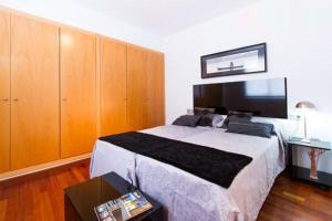 a bedroom with a large bed and wooden cabinets at Happy Apartments Valencia in Valencia