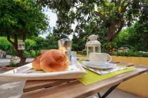 a table with a plate of bread and a cup of coffee at Lumia e Zagara in Taormina +27 photos