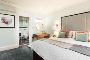 a bedroom with a large bed and a bathroom at Lancaster Gate Hyde Park by London Hotel Collection in London