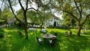 een tafel en stoelen in een tuin met bomen bij Kendov Dvorec in Spodnja Idrija