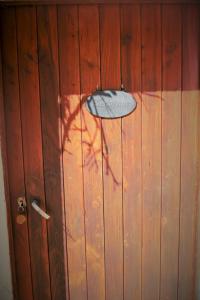 a surfboard is hanging on a wooden wall at Au Temps de la Source in Raon-aux-Bois