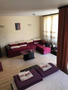 a living room with a couch and a living room with purple furniture at Nestinarka Complex - Emili Apartment in Tsarevo +76 photos