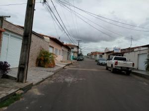 an empty street with a white truck parked on the street at casa em condomínio in São Luís