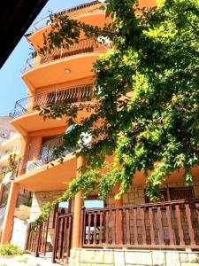 スヴェティ・ヴラスにあるJoro Guest Houseの目の前に木が立つ高いオレンジ色の建物