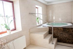 a bathroom with a tub and a sink and stairs at Central Apartmany in Starý Smokovec