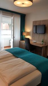 1 dormitorio con 1 cama y escritorio con ordenador en StadtHotel Bad Fallingbostel en Bad Fallingbostel