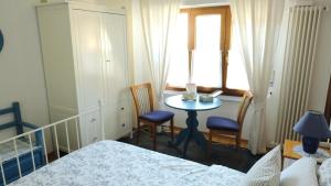 een slaapkamer met een tafel en 2 stoelen en een raam bij B&B Mamma Mia in Pisano