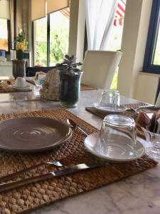 une table avec des assiettes et des ustensiles dans l'établissement B&B Il Portico, à Sarzana