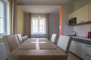 a kitchen with a wooden table with chairs and a kitchen at Pensjonat Spoko Słonia w Rewalu in Rewal +13 photos