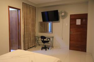 Un dormitorio con un escritorio y un televisor en la pared. en Hotel Vicente de la Vega, en Chiclayo 18 fotos más