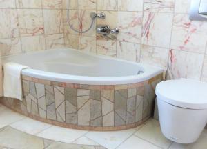 a bathroom with a bath tub and a toilet at Ferienhaus Waldernbach in Mengerskirchen