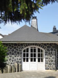 uma casa de pedra com uma porta branca e uma janela em Ferienhaus Waldernbach em Mengerskirchen