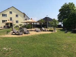 eine Gruppe von Stühlen und Sonnenschirmen auf einem Hof in der Unterkunft Gästehaus am See in Gaienhofen