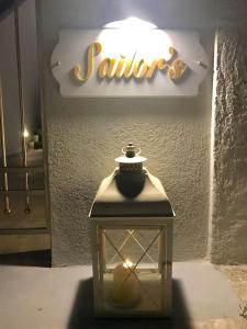a lantern in front of a sign with a light at Sailor's Nautical Concept in Spetses