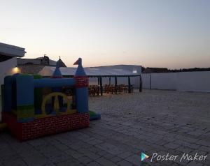 een speeltuin met een speelset en tafels en de zonsondergang bij Locazione turistica Green Park in Martina Franca