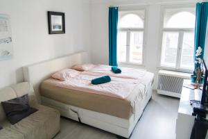ブダペストにあるQueen Bed Central Budapestのベッドルーム1室(青いカーテンと椅子付きのベッド1台付)