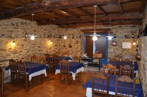 restauracja z niebieskimi stołami i krzesłami w kamiennej ścianie w obiekcie Casa Assumpta w mieście Arzúa +14 zdjęć