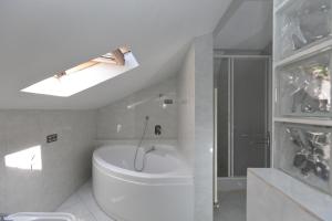 y baño blanco con aseo y ducha. en Maren, en Nizza Monferrato
