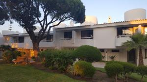 un edificio bianco con un albero di fronte di Victory Village Club, Quinta do Lago a Quinta do Lago