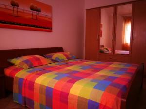 ein Schlafzimmer mit einem farbenfrohen Bett und einem Spiegel in der Unterkunft Marko Apartment in Pula