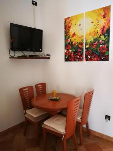 einen Esstisch mit Stühlen und ein Gemälde an der Wand in der Unterkunft Marko Apartment in Pula